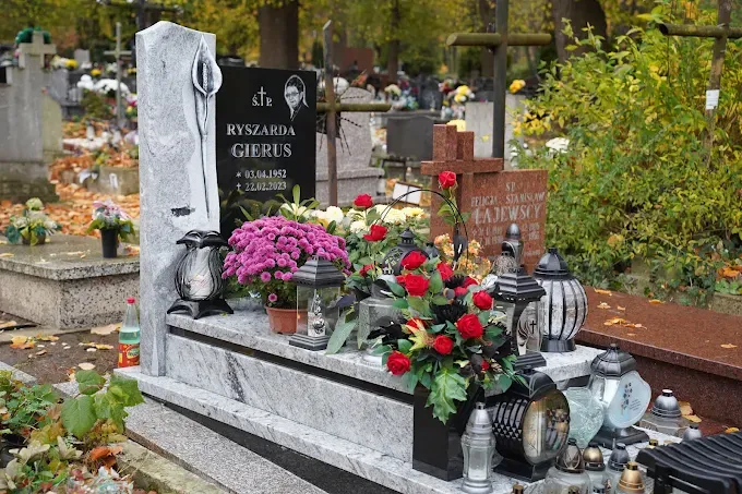 Nowoczesny nagrobek z jasnego granitu z rzeźbionym motywem kalii i czarną tablicą z portretem