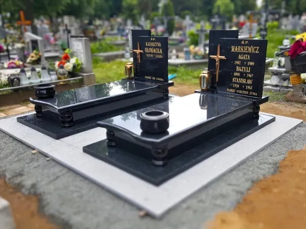 Dwa identyczne nagrobki pojedyncze z czarnego polerowanego granitu z narożnymi kolumienkami i złotym liternictwem