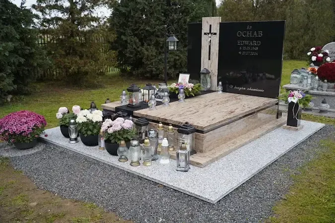Nowoczesny nagrobek z jasnego granitu z czarną tablicą napisową i otoczeniem z kostki