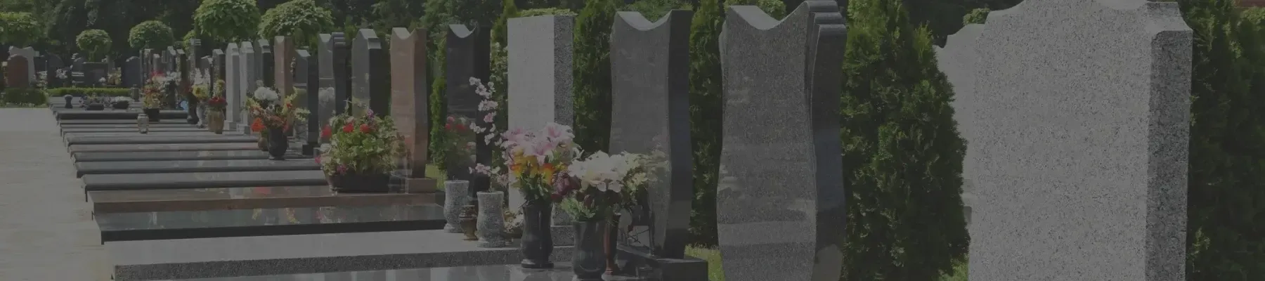 Rząd granitowych nagrobków z kwiatami na cmentarzu