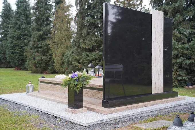 Nagrobek z czarnego polerowanego granitu z jasną pionową wstawką i czarnym wazonem