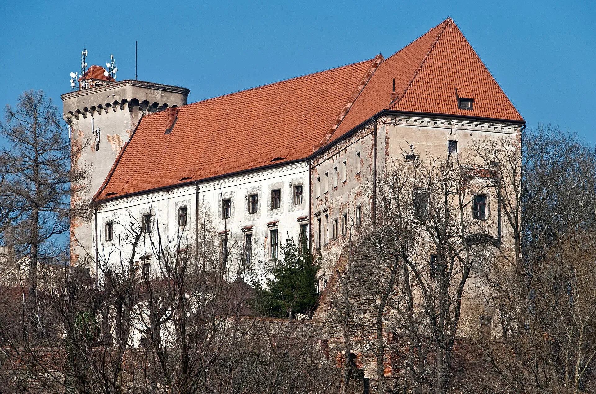 Zamek w Otmuchowie na wzgórzu z czerwonym dachem i wieżą